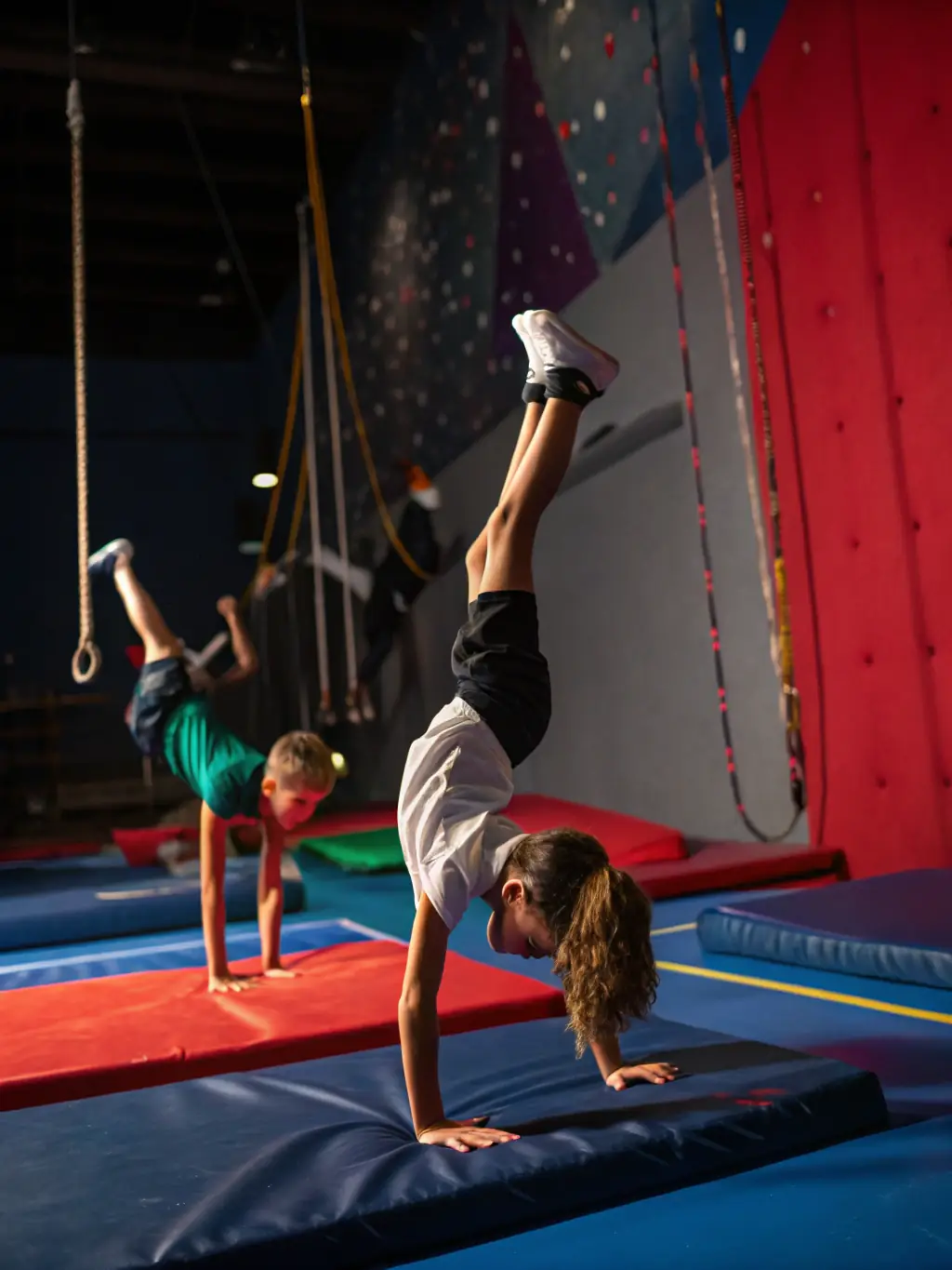 A dynamic image of gymnasts performing advanced skills during a competition, showcasing the dedication and skill development within the club.